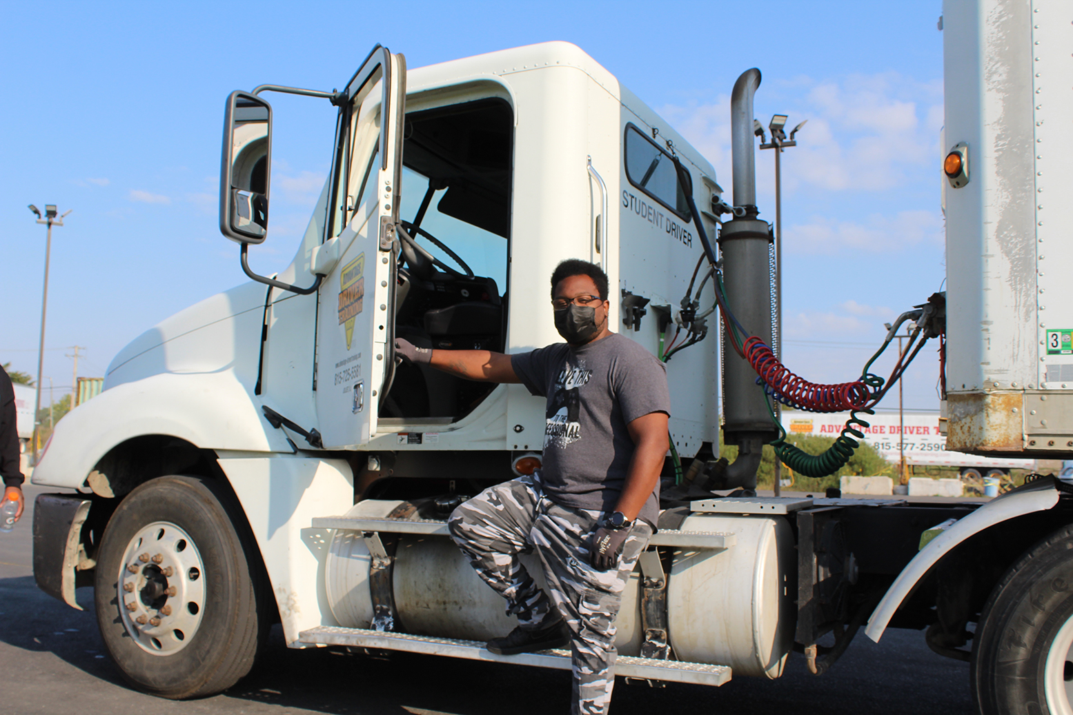 student standing near semi truck