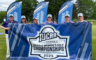 six people pose for photo behind banner on golf course
