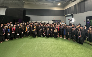 graduates pose for photo indoors
