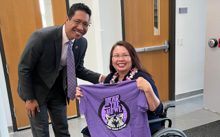 Dr. Clyne Namuo and Sen. Tammy Duckworth pose for photo with purple JJC Hear the Howl T-shirt