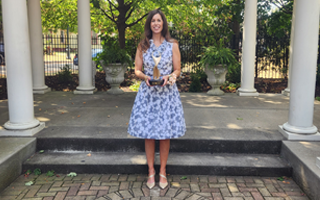 Kelly Rohder-Tonelli poses for photo with award statue in hand