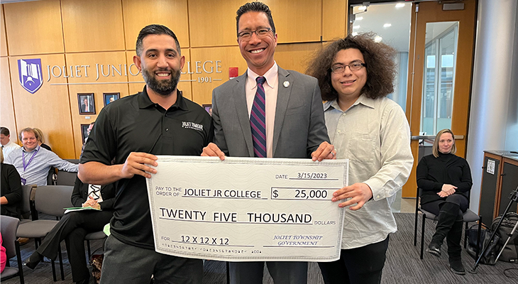 three people pose for photo with large check