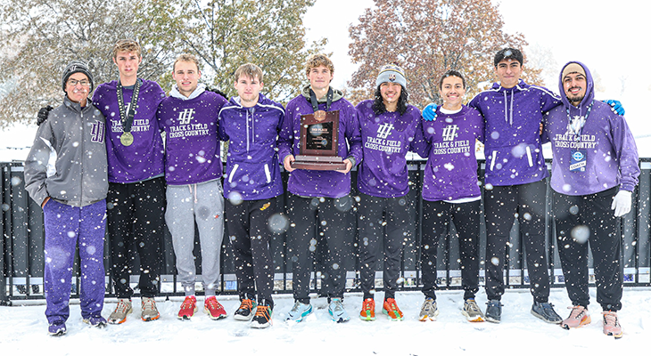 JJC men's cross country team and coaches pose for photo with trophy outdoors in snow