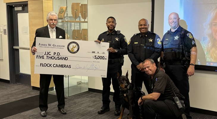 Will County State's Attorney James Glasgow poses for photo with four JJC PD officers and Storm the police dog while holding/presenting large check