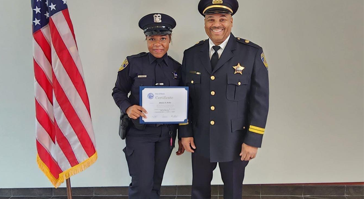 Officer Griffin holds certificate of completion while posing for photo with Commander Tracy Williams