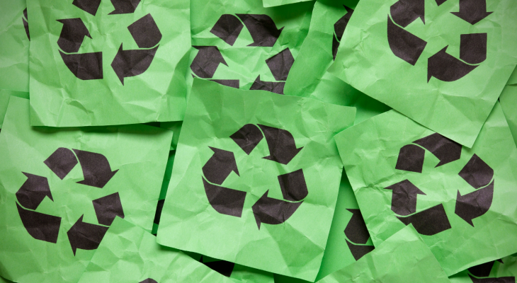 green papers with black recycle symbol